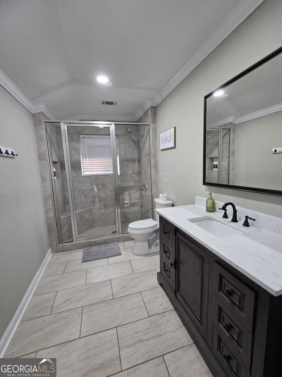 402 Meriwether Street Griffin, GA 30224 - Photo 15 of 36 a spacious bathroom with a shower sink and mirror
