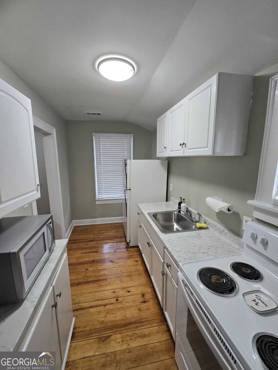402 Meriwether Street Griffin, GA 30224 - Photo 24 of 36 a kitchen with a stove and a sink