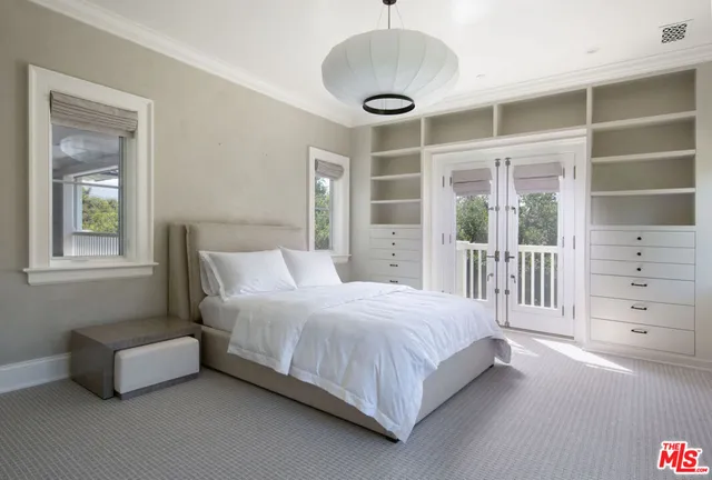 a bedroom with bed couch and window