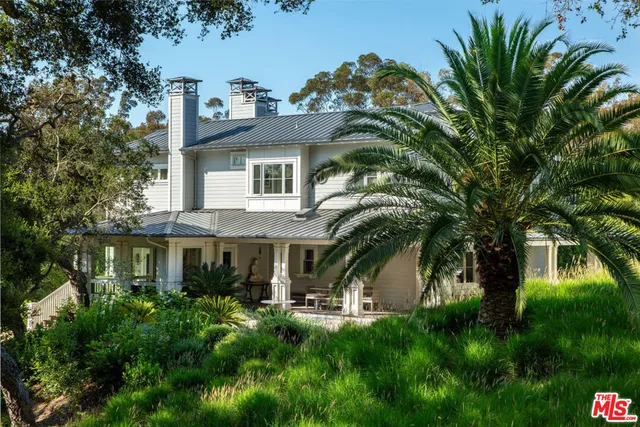 a backyard of a house with lots of plants and trees