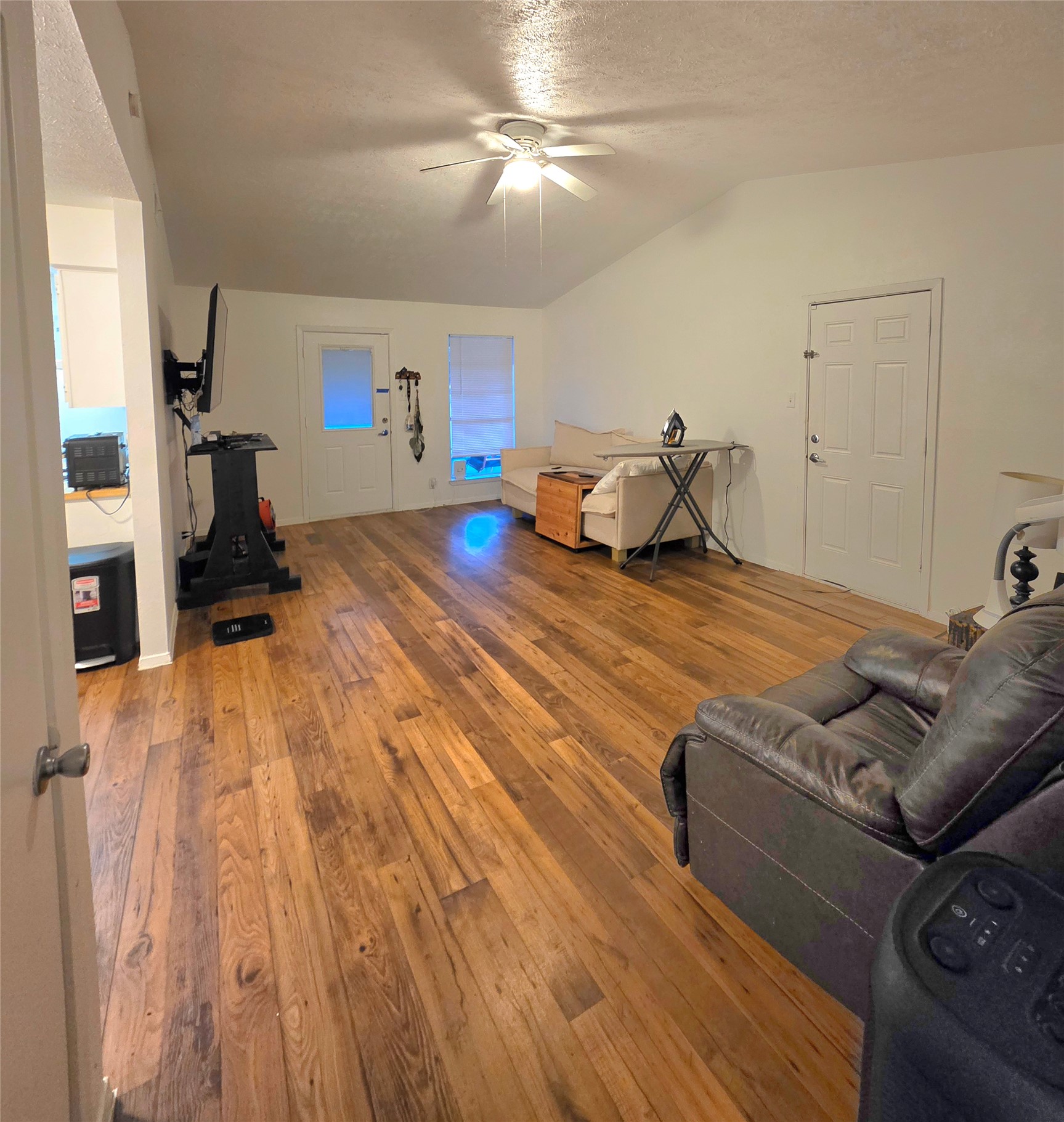 15208 Spring Hill Lane, Unit A Pflugerville, TX 78660 - Photo 5 of 16 Spacious room featuring wood-finish flooring, vaulted ceilings, and a ceiling fan