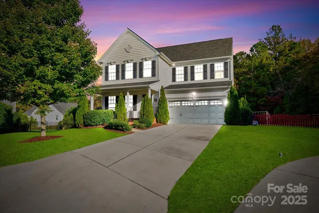 a front view of a house with a yard and green space