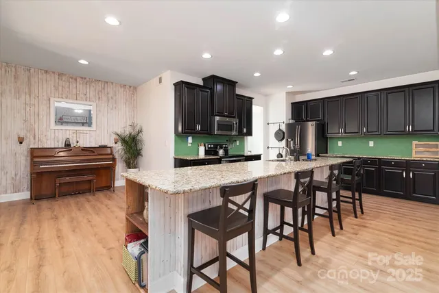 a kitchen with stainless steel appliances granite countertop sink stove top oven and cabinets
