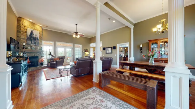 a living room with furniture kitchen view and a chandelier