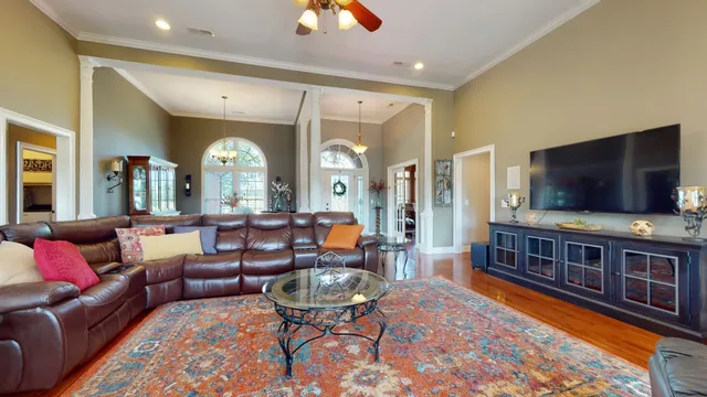 a living room with furniture a flat screen tv and a large window