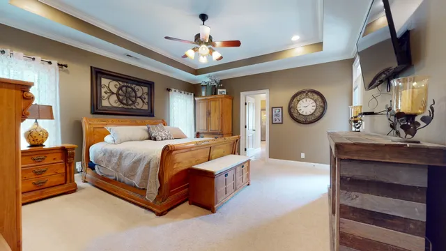 a spacious bedroom with a bed and a chandelier