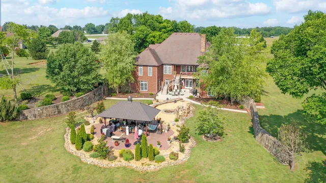 a view of a house with backyard and sitting area