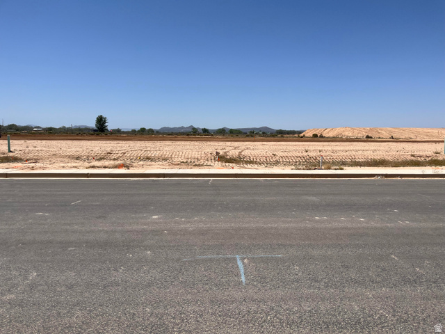 5119 North 75 East, Unit 208 Enoch, UT 84721 - Photo 4 of 14 Vacant land parcel featuring an expansive, level terrain with visible mountain range in the distance and clear blue skies
