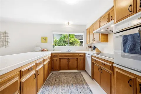 a kitchen with stainless steel appliances sink cabinets and wooden floor