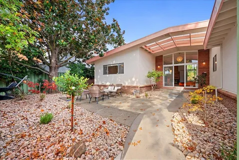 a backyard of a house with table and chairs