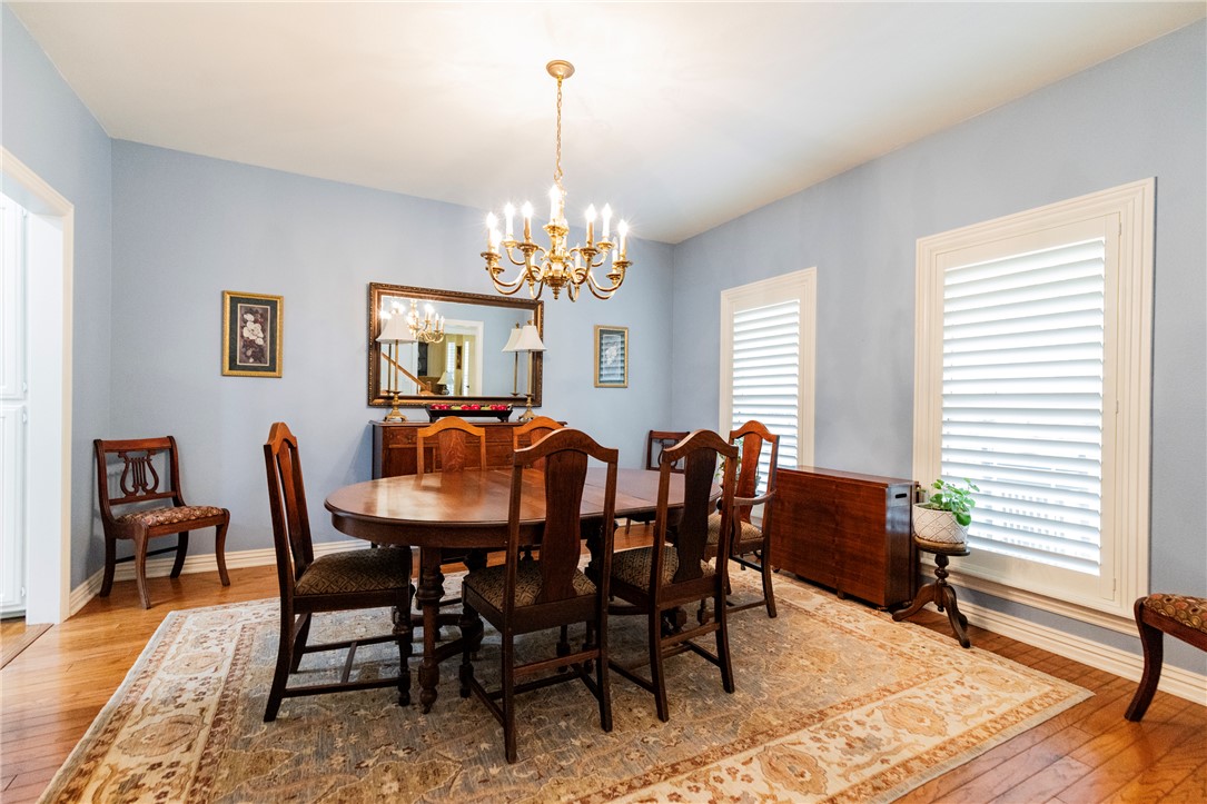 14203 Greenridge Road Fayetteville, AR 72701 - Photo 15 of 25 Dining area featuring wood-finish flooring, a brass chandelier, and light blue walls