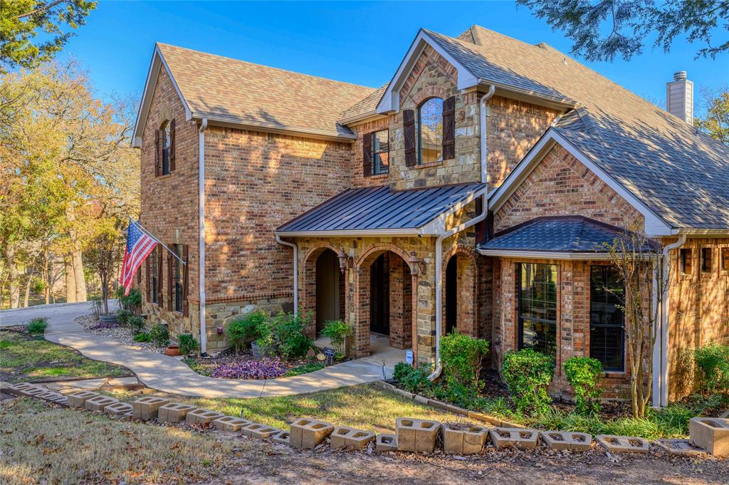 588 Lakepoint Loop Pottsboro, TX 75076 - Photo 9 of 39 a view of a brick house with plants and large tree