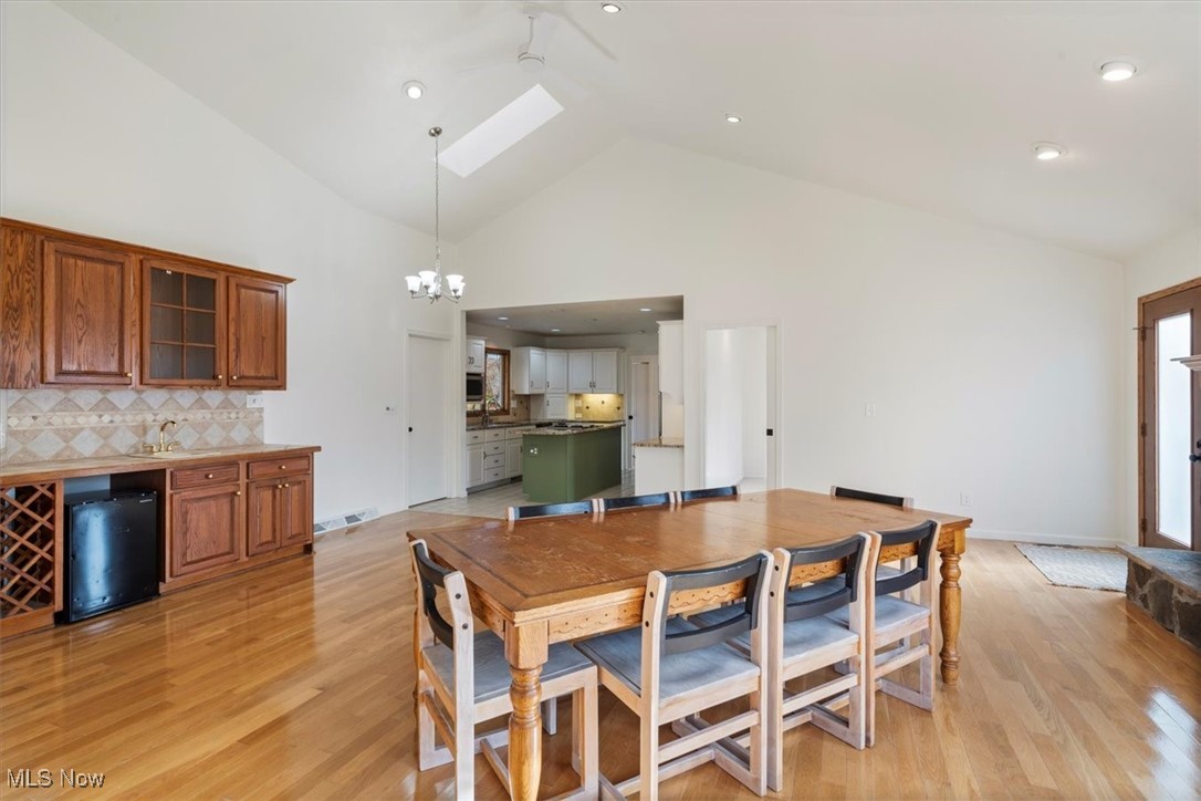 3520 Hunting Run Road Medina, OH 44256 - Photo 18 of 47 Dining room with high vaulted ceiling, sink, a skylight, light hardwood / wood-style flooring, and a chandelier