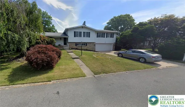 a front view of a house with a garden and yard