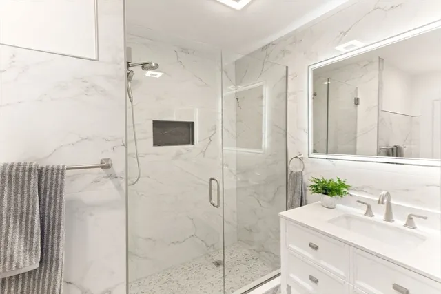 a bathroom with a shower sink and mirror
