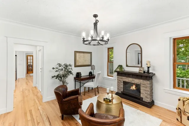 a living room with furniture a fireplace and a chandelier