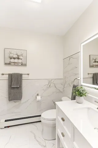 a bathroom with a sink a toilet and mirror