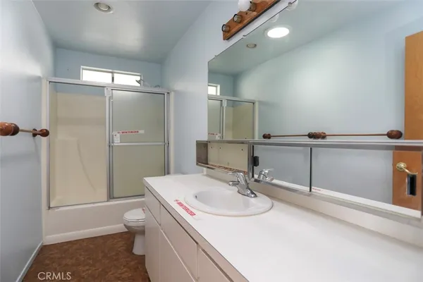 a bathroom with a granite countertop shower a sink and a mirror