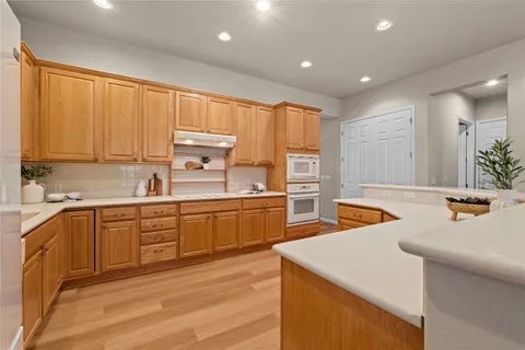 a kitchen with stainless steel appliances kitchen island a table and chair in it