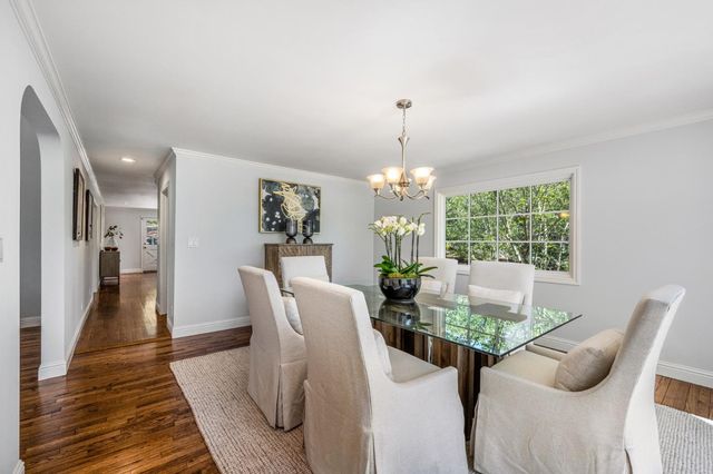 a view of a dining room with furniture wooden floor and chandelier