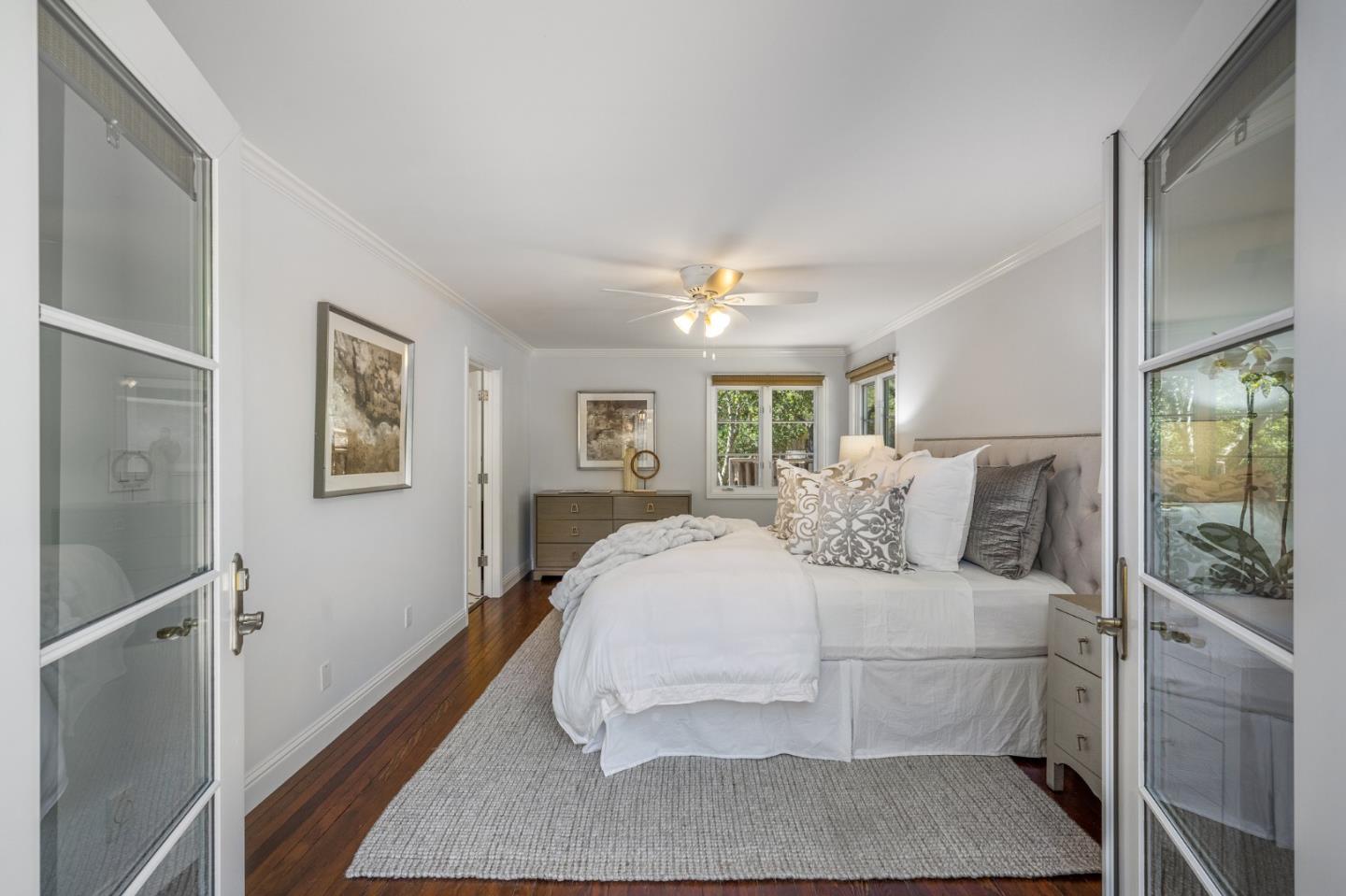 1585 Canada Lane Woodside, CA 94062 - Photo 19 of 46 a bedroom with a large bed and a chandelier