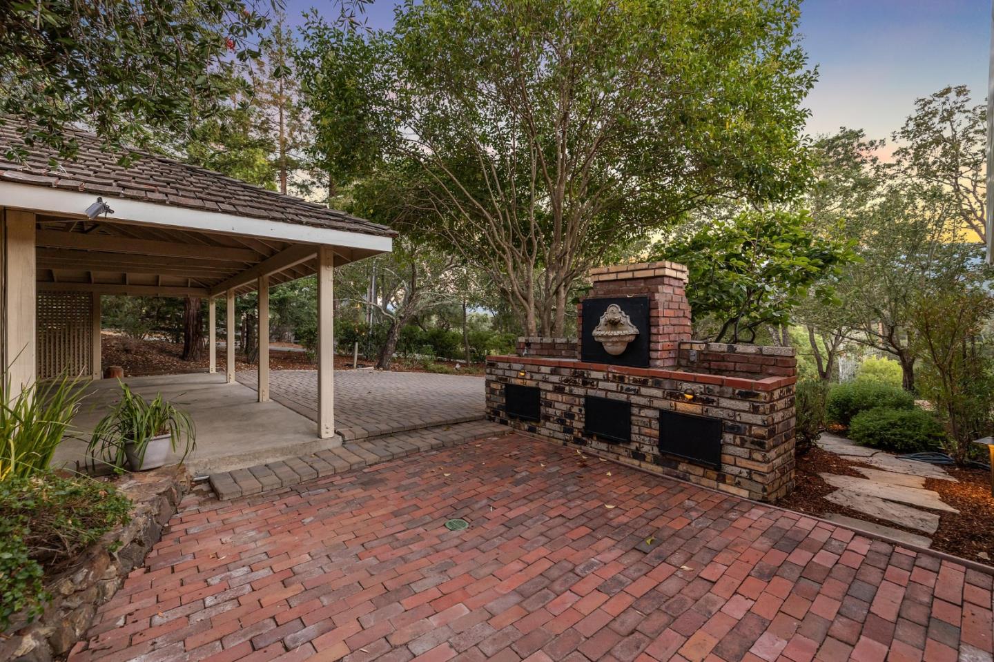 1585 Canada Lane Woodside, CA 94062 - Photo 40 of 46 a view of a patio with table and chairs under an umbrella with large trees