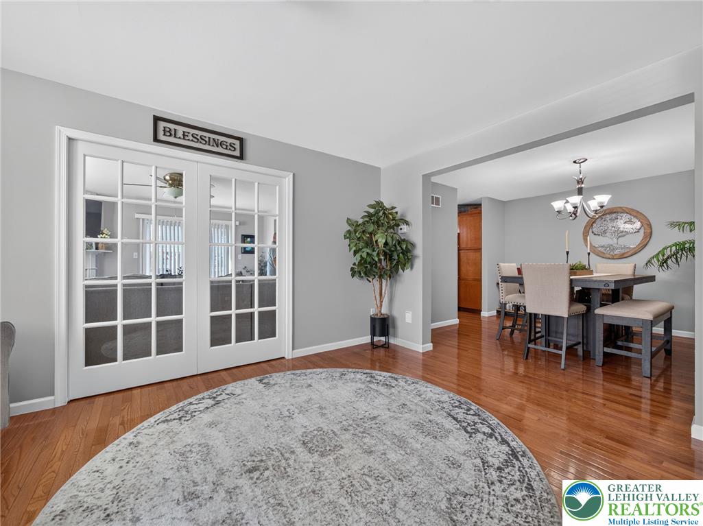 4148 Ross Road Bethlehem, PA 18020 - Photo 45 of 67 Elegant French doors define a dedicated space with gleaming hardwood flooring and a dining area beyond.