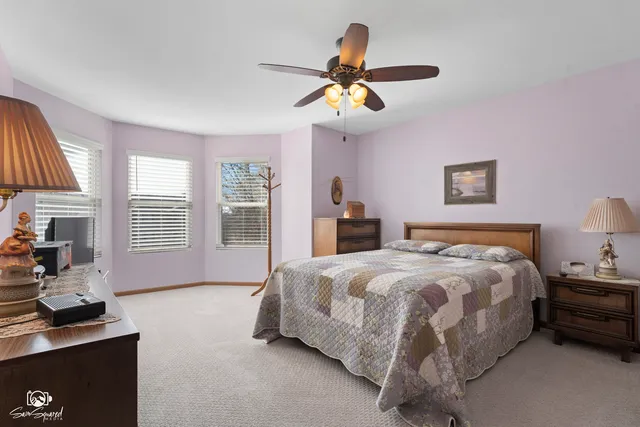 a spacious bedroom with a bed and a chandelier