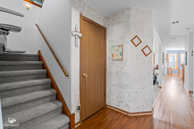 a view of a hallway with wooden floor and stairs