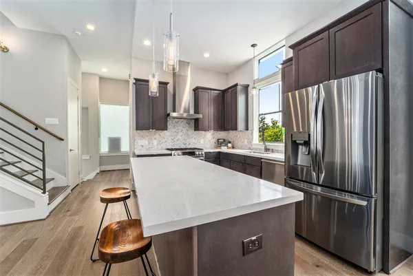 a kitchen with stainless steel appliances a refrigerator and a stove top oven
