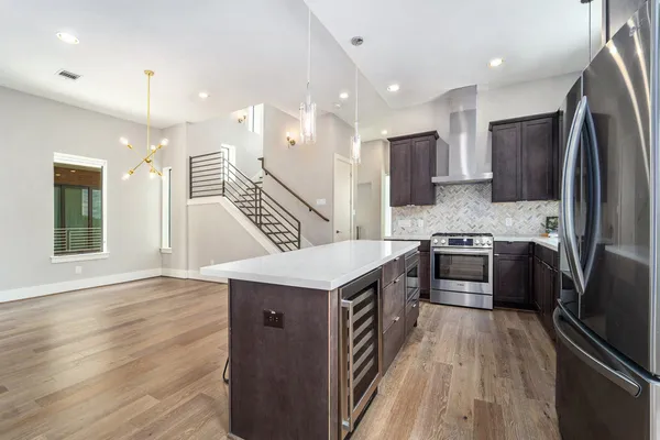 a kitchen with kitchen island stainless steel appliances a sink cabinets and wooden floor