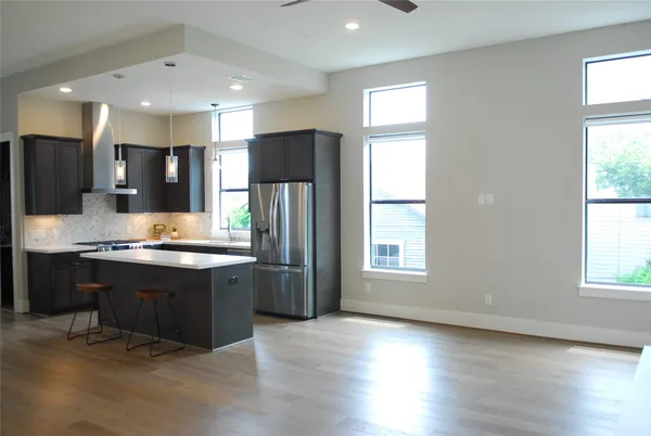 a large kitchen with stainless steel appliances granite countertop a stove a sink and a refrigerator