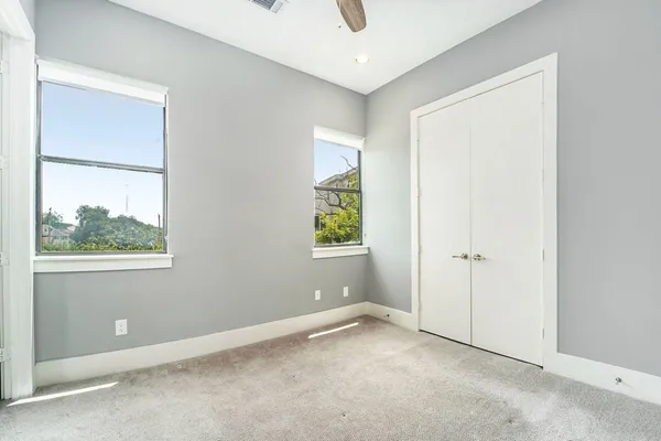 an empty room with windows and closet