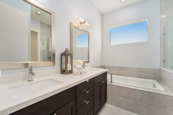 a bathroom with a tub sink and mirror
