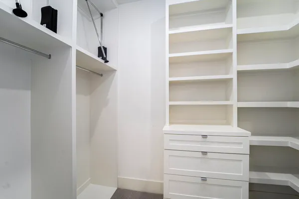 a view of walk in closet with empty racks