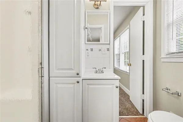 a bathroom with a sink a toilet and a mirror