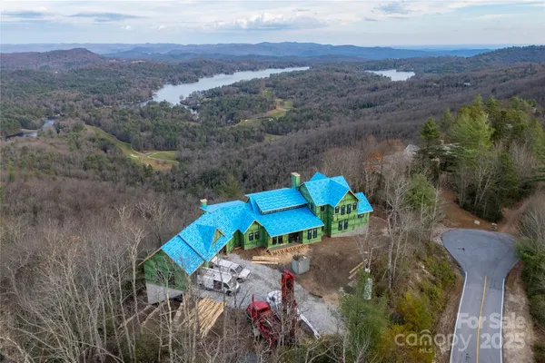 an aerial view of a house with a mountain