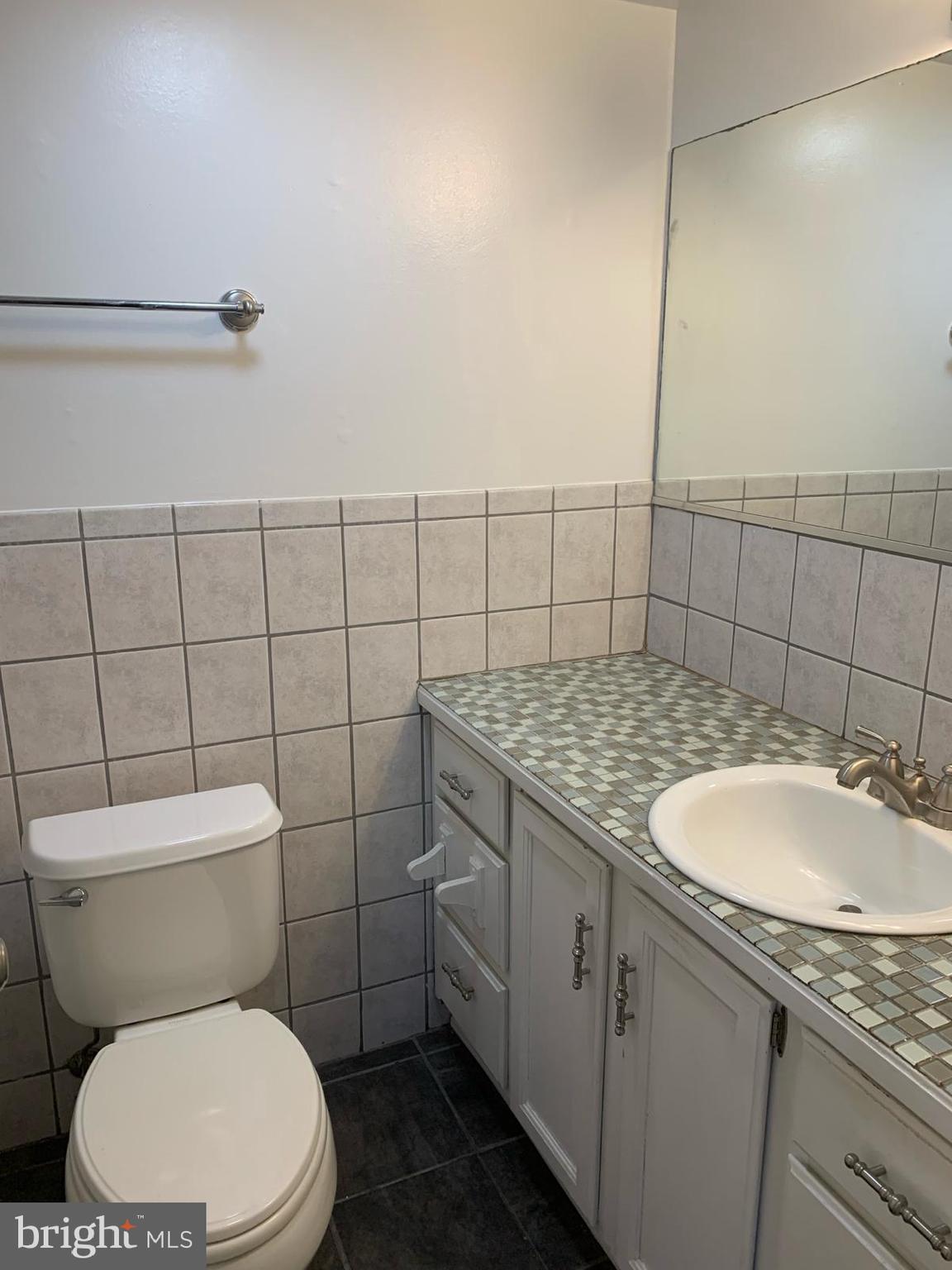 2911 Charing Cross Road, Unit 10 Falls Church, VA 22042 - Photo 14 of 25 a bathroom with a granite countertop toilet sink and mirror