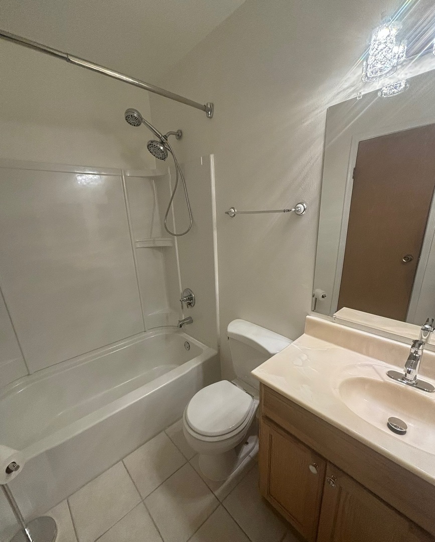2028 North Rand Road, Unit 104 Palatine, IL 60074 - Photo 7 of 9 a bathroom with a sink a toilet and shower
