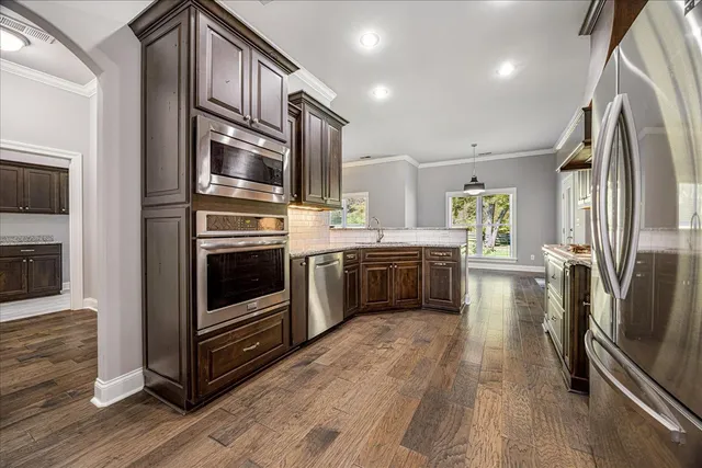 a kitchen with stainless steel appliances a stove a sink and a refrigerator