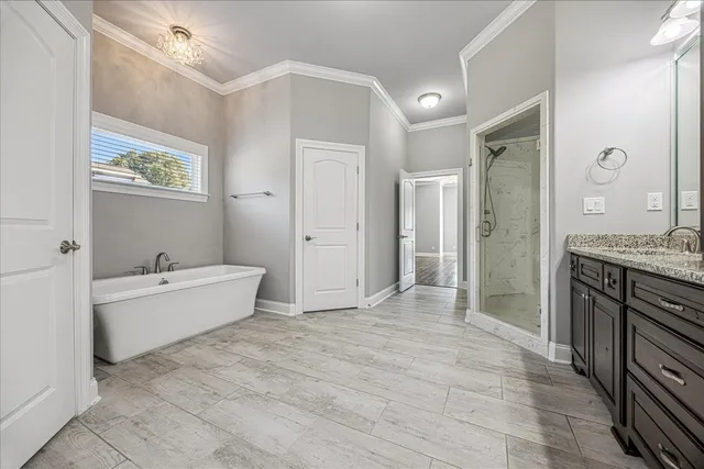 a spacious bathroom with a tub sink shower and mirror
