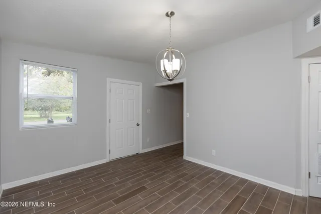 a view of a room with wooden floor and window