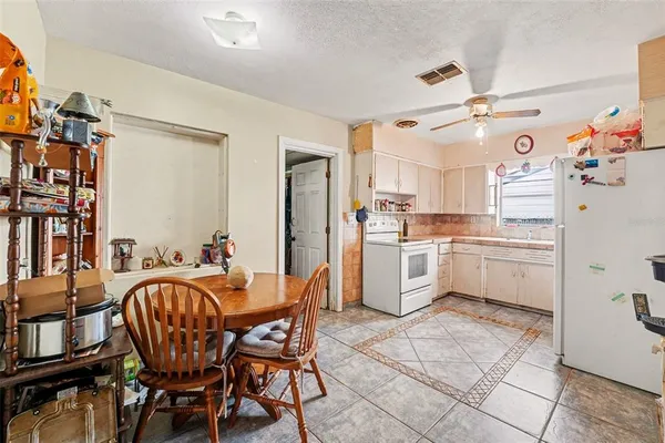 a kitchen with a table chairs refrigerator and cabinets