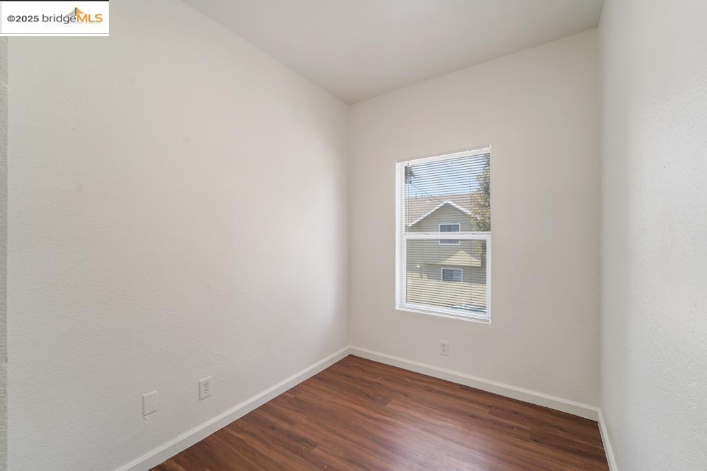 203 Bissell Avenue Richmond, CA 94801 - Photo 16 of 30 a view of an empty room with wooden floor and a window