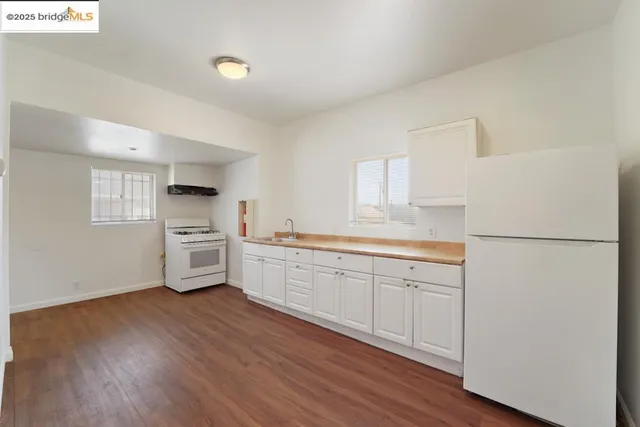 a kitchen with granite countertop white cabinets and white appliances
