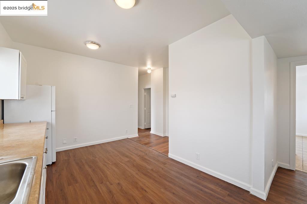 203 Bissell Avenue Richmond, CA 94801 - Photo 10 of 30 an empty room with wooden floor and a sink