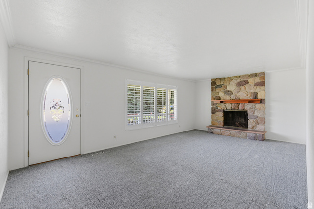 148 Tennyson Avenue Sandy, UT 84070 - Photo 8 of 55 Living area featuring a stone-clad fireplace with a wood mantel, light gray carpet flooring, and white walls