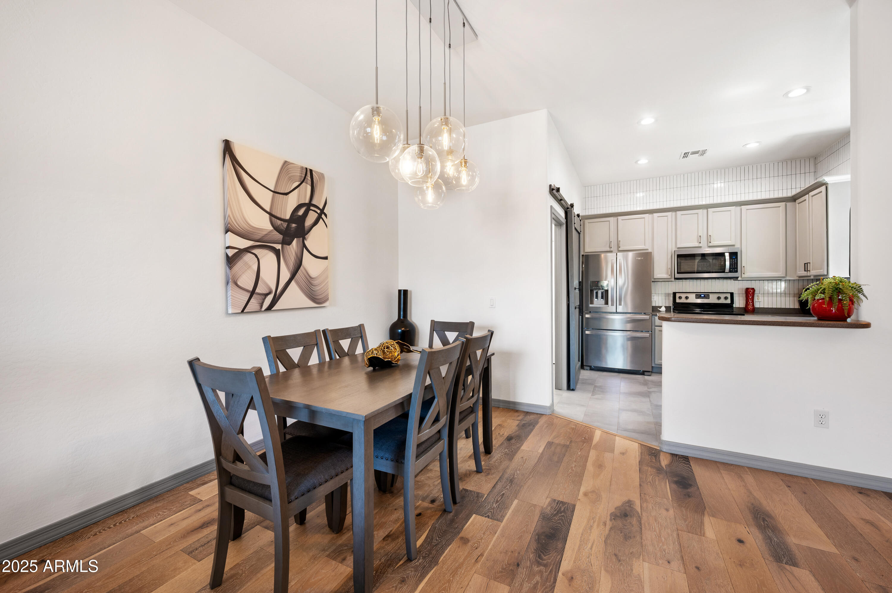 10172 East Dinosaur Ridge Road Gold Canyon, AZ 85118 - Photo 9 of 38 a kitchen with stainless steel appliances a dining table chairs refrigerator and microwave