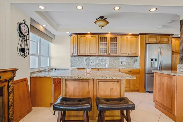 a kitchen with stainless steel appliances granite countertop a sink and a refrigerator