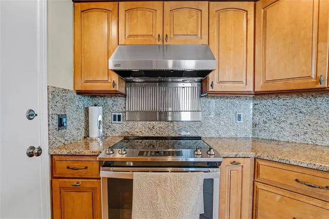 a kitchen with granite countertop a stove and a sink